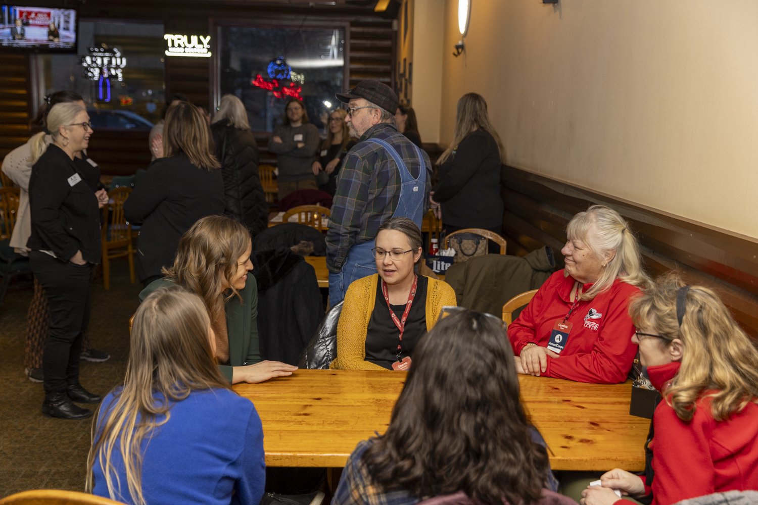People engaged in conversation at a social gathering in a restaurant.