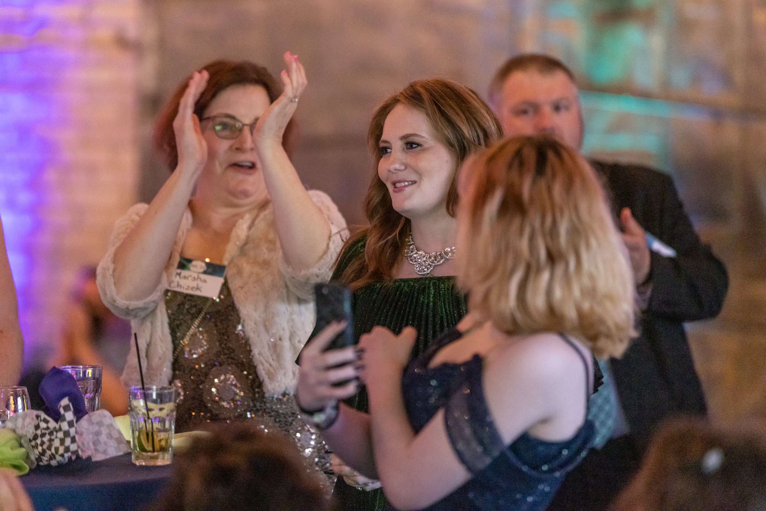 Group of people at an event, one person clapping.