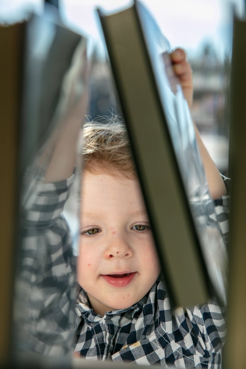 Child looking through books on a shelf