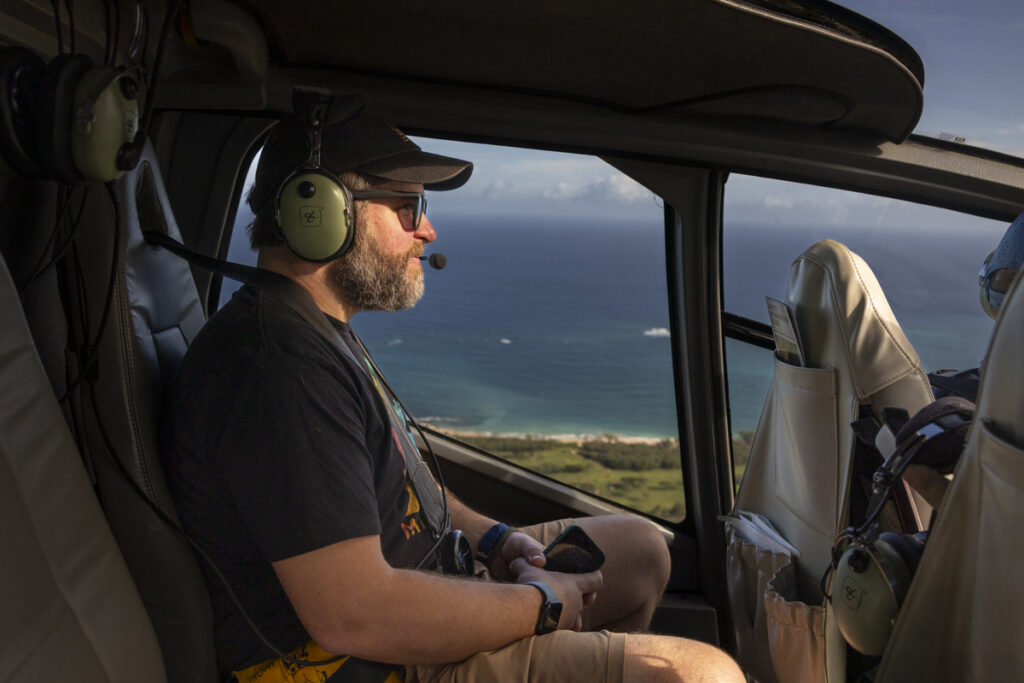 Passenger looking out window of Maverick Helicopter over Maui coastline
